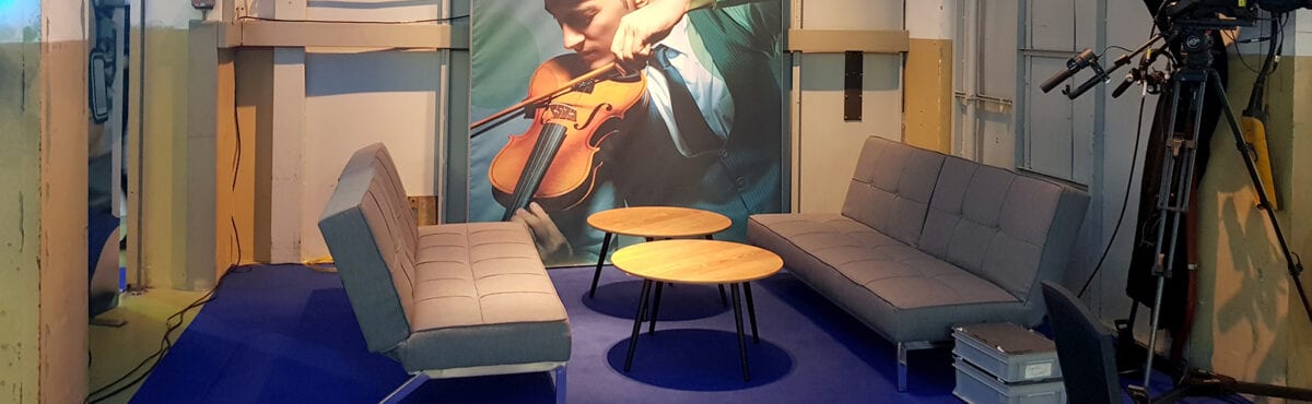Violetter Eventteppich mit grauen Sofas an Videodreh